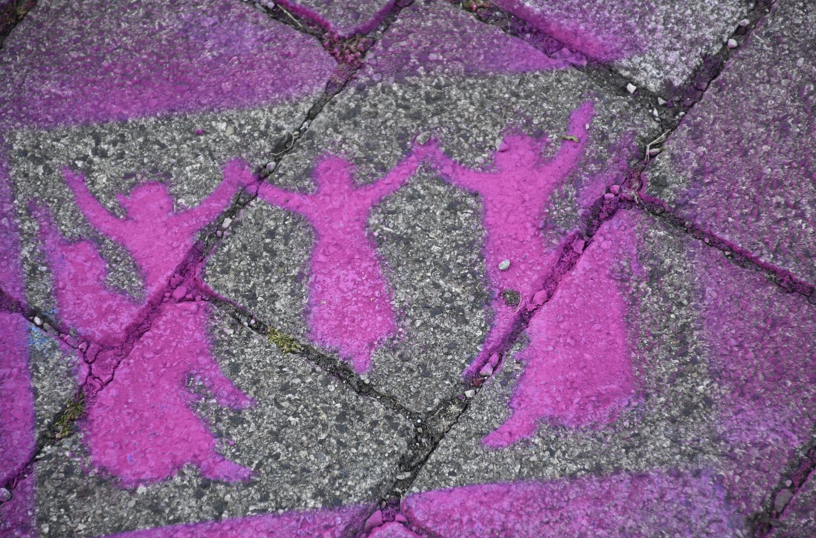 Pinke Figuren auf Pflastersteinen